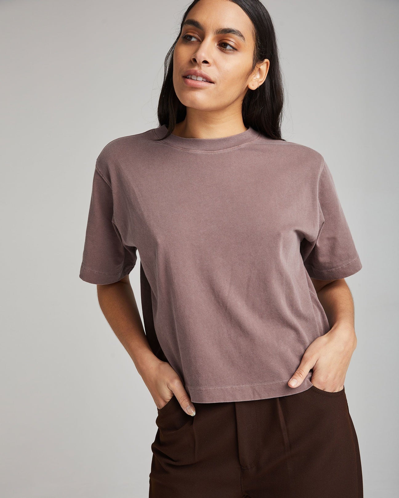 front view of a woman wearing a relaxed fit short sleeve cropped t-shirt in a faded purple color called plum smoke