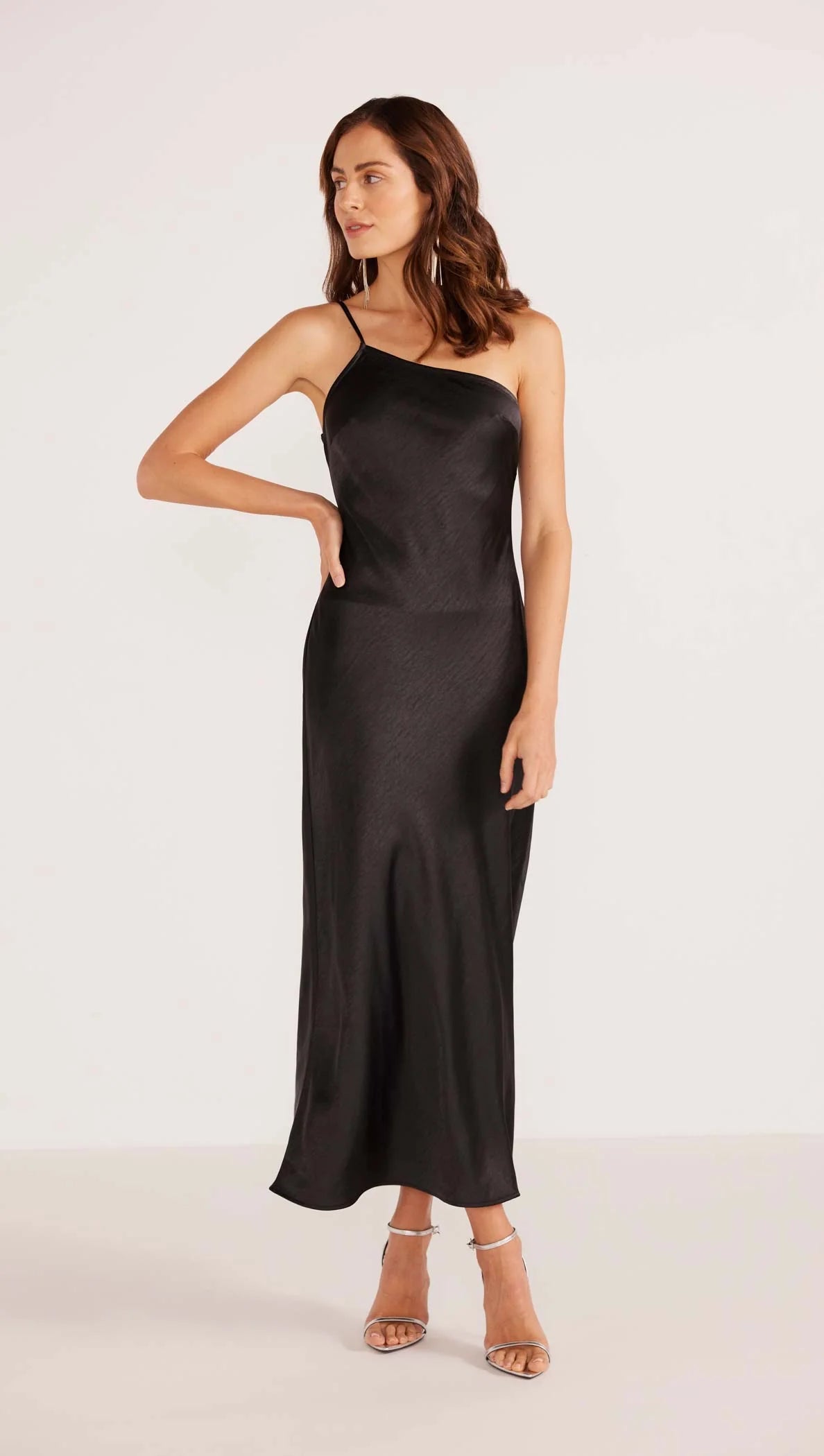 A woman wearing the black Ella One Shoulder Midi Dress by the brand MINKPINK