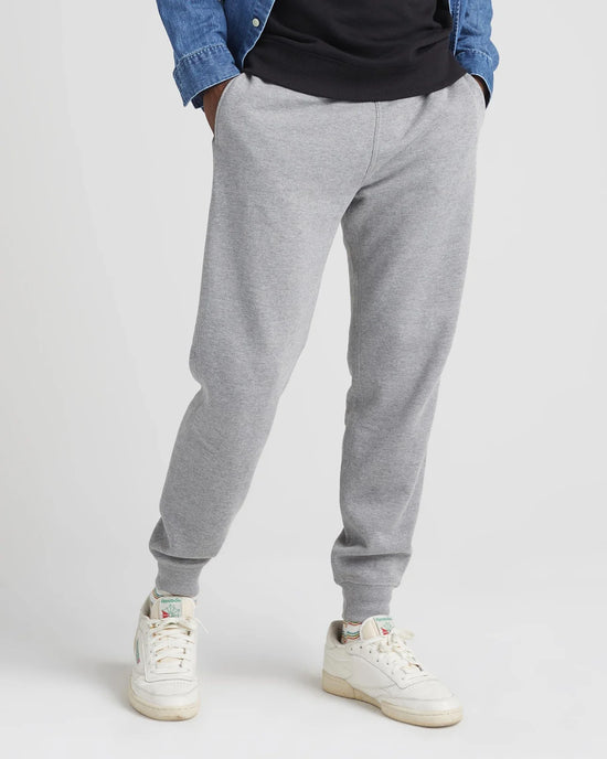 Front view of model wearing recycled fleece tapered sweatpant in color heather grey