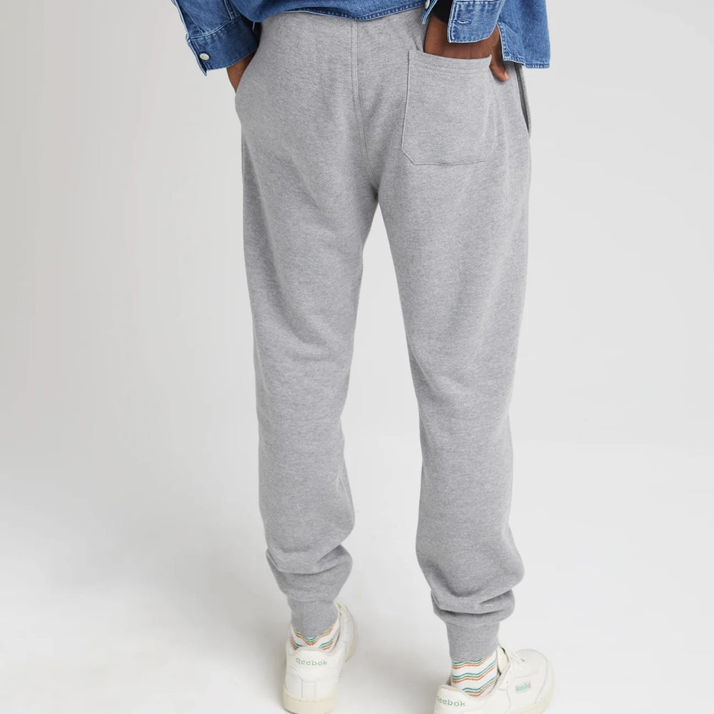 
                      
                        back view of model wearing recycled fleece tapered sweatpant in color heather grey. The pants have a single back pocket
                      
                    