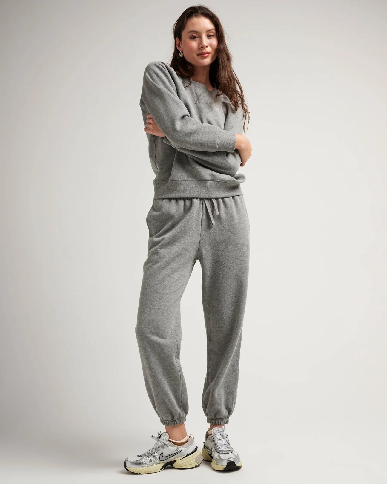 view of model wearing recycled fleece classic sweatpant in color heather grey