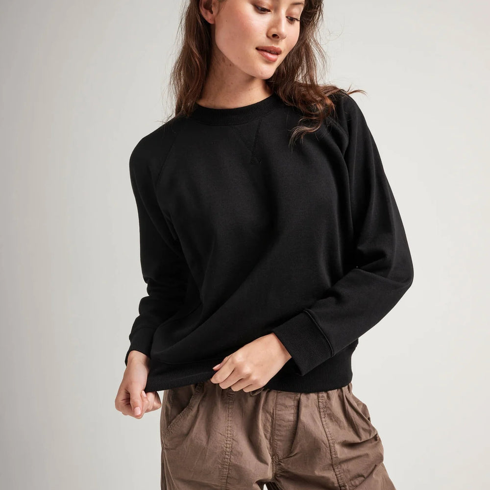 Front view of model wearing a crewneck recycled fleece sweatshirt in color black
