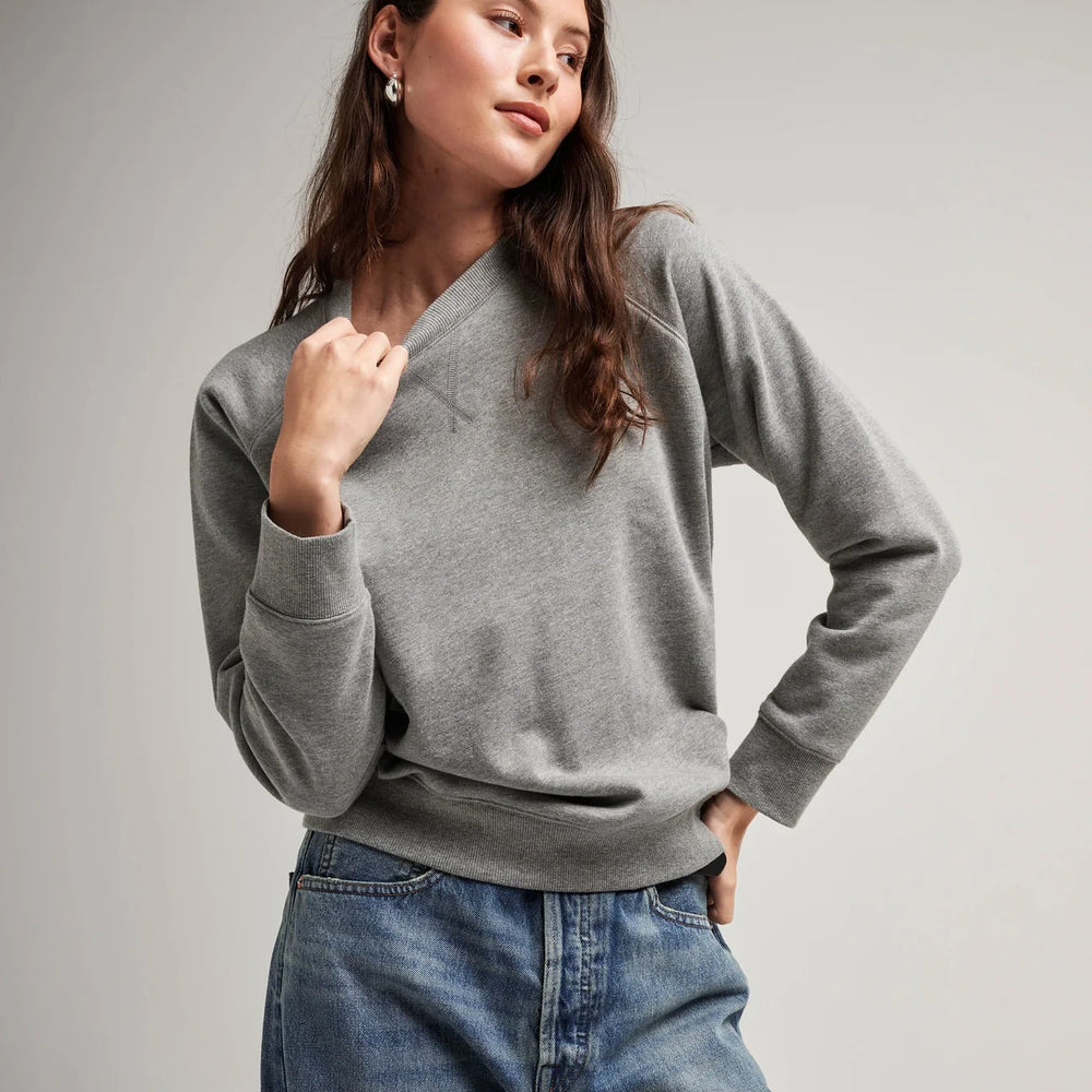 Front view of model wearing a crewneck recycled fleece sweatshirt in color heather grey
