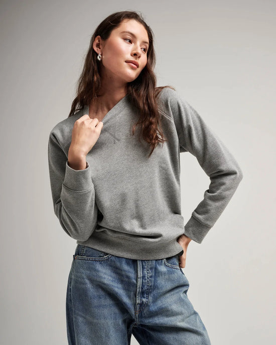 Front view of model wearing a crewneck recycled fleece sweatshirt in color heather grey