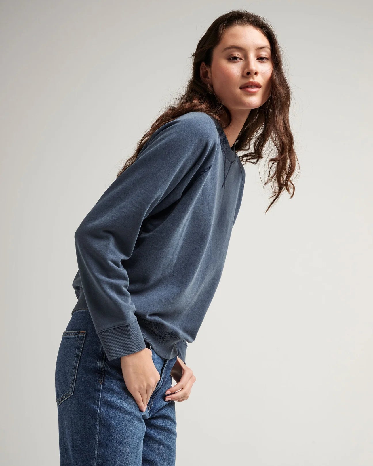 Side view of model wearing a crewneck recycled fleece sweatshirt in color mineral moonlit ocean