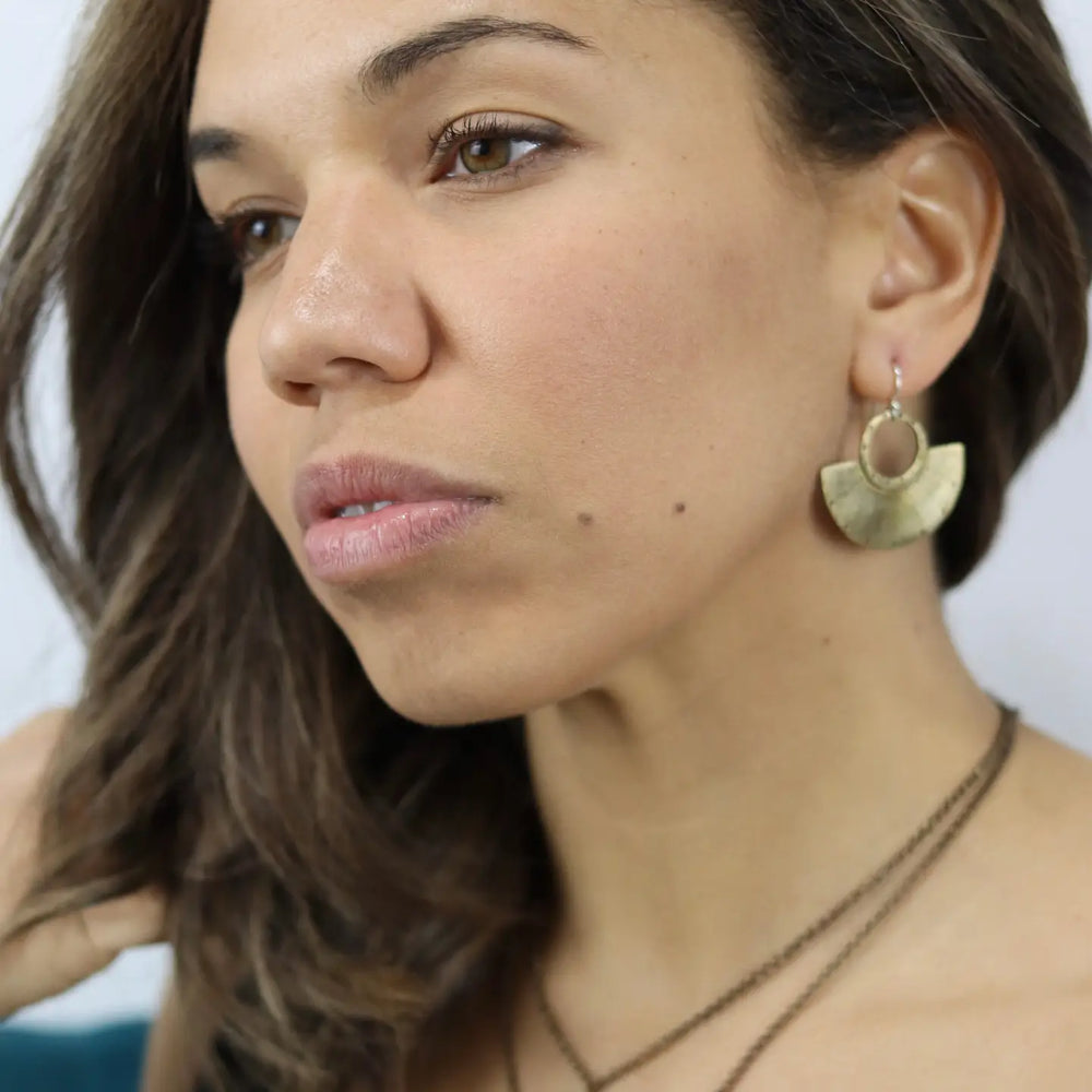 
                      
                        A woman wearing the Brass Neo Mezza Earrings by Jennifer Kahn Jewelry
                      
                    