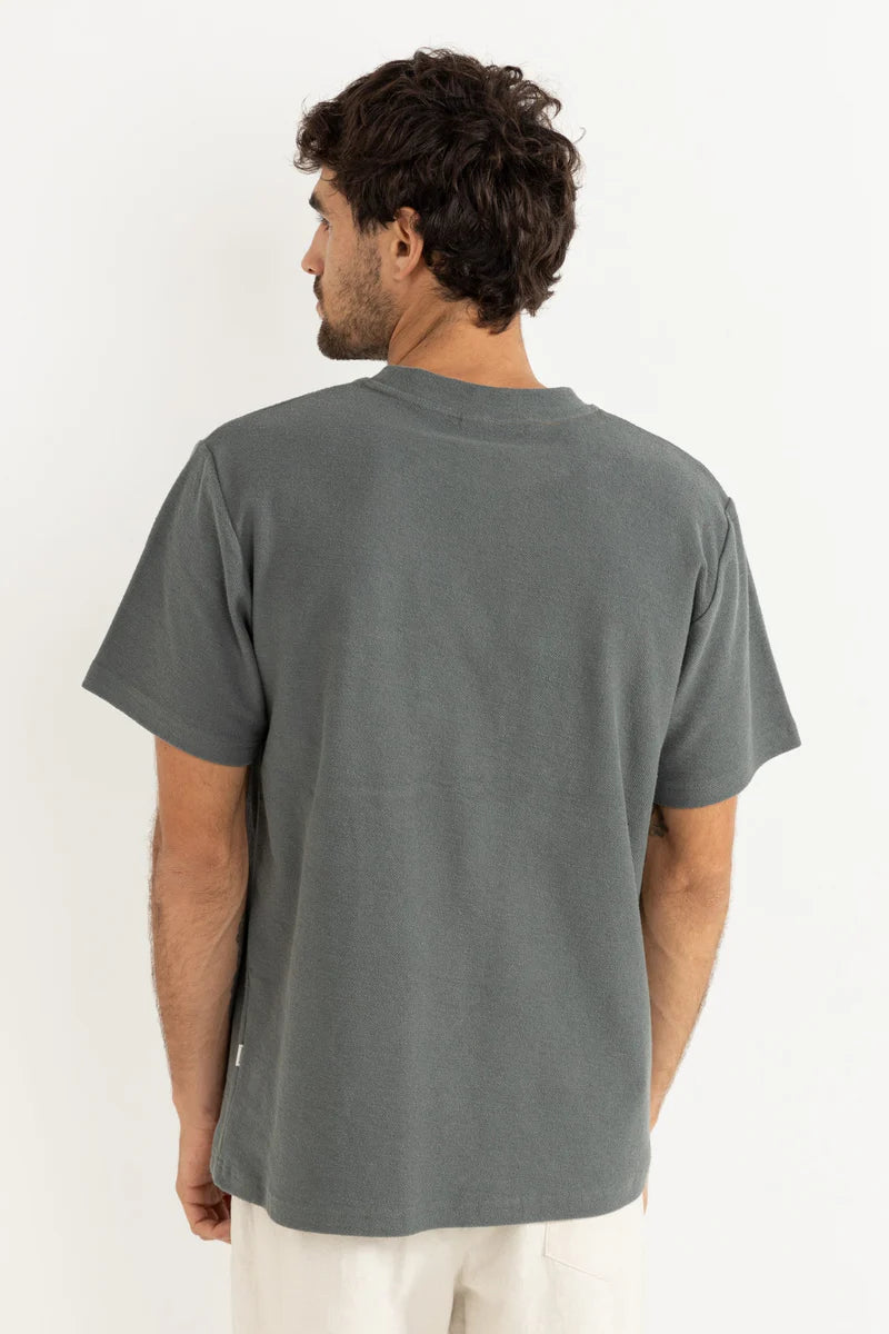 Man wearing a gray t-shirt by Rhythm on a white background
