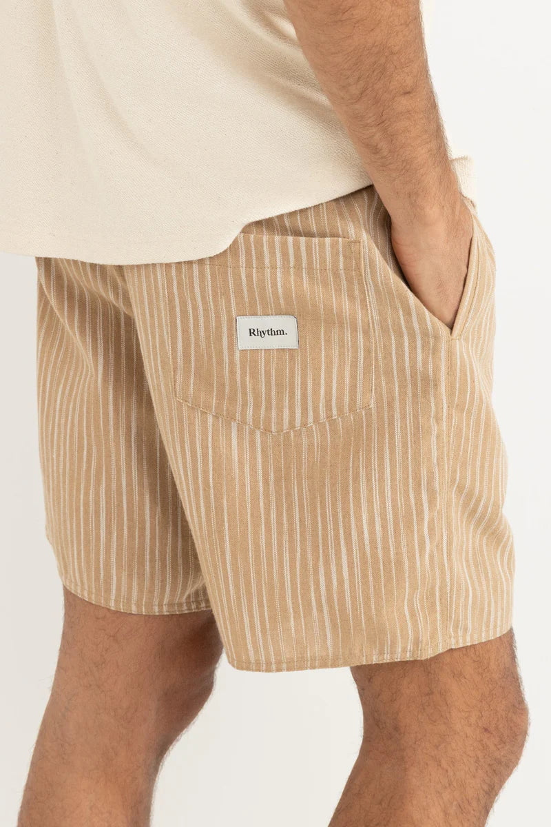 Beige striped shorts worn by a person on a white background