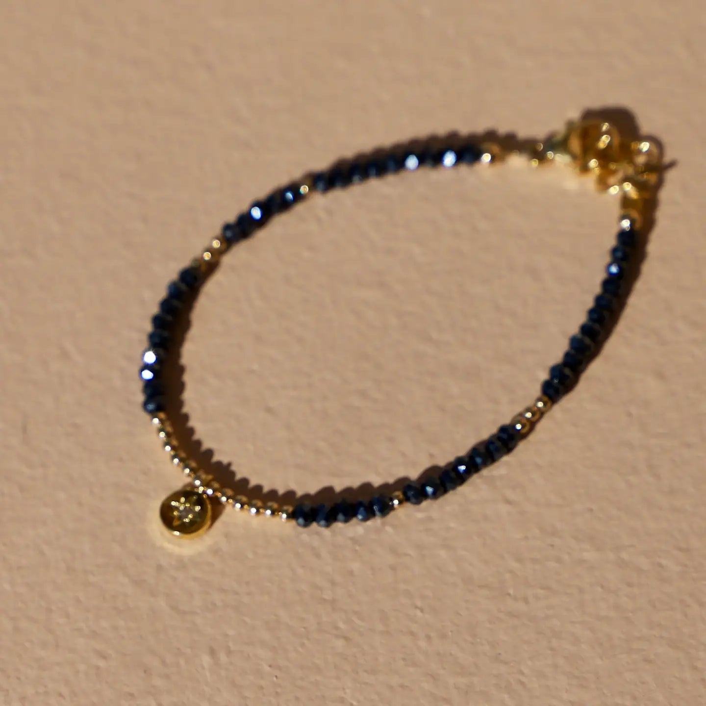 Bracelet with single layer petite crystal with gold accents and star pendant