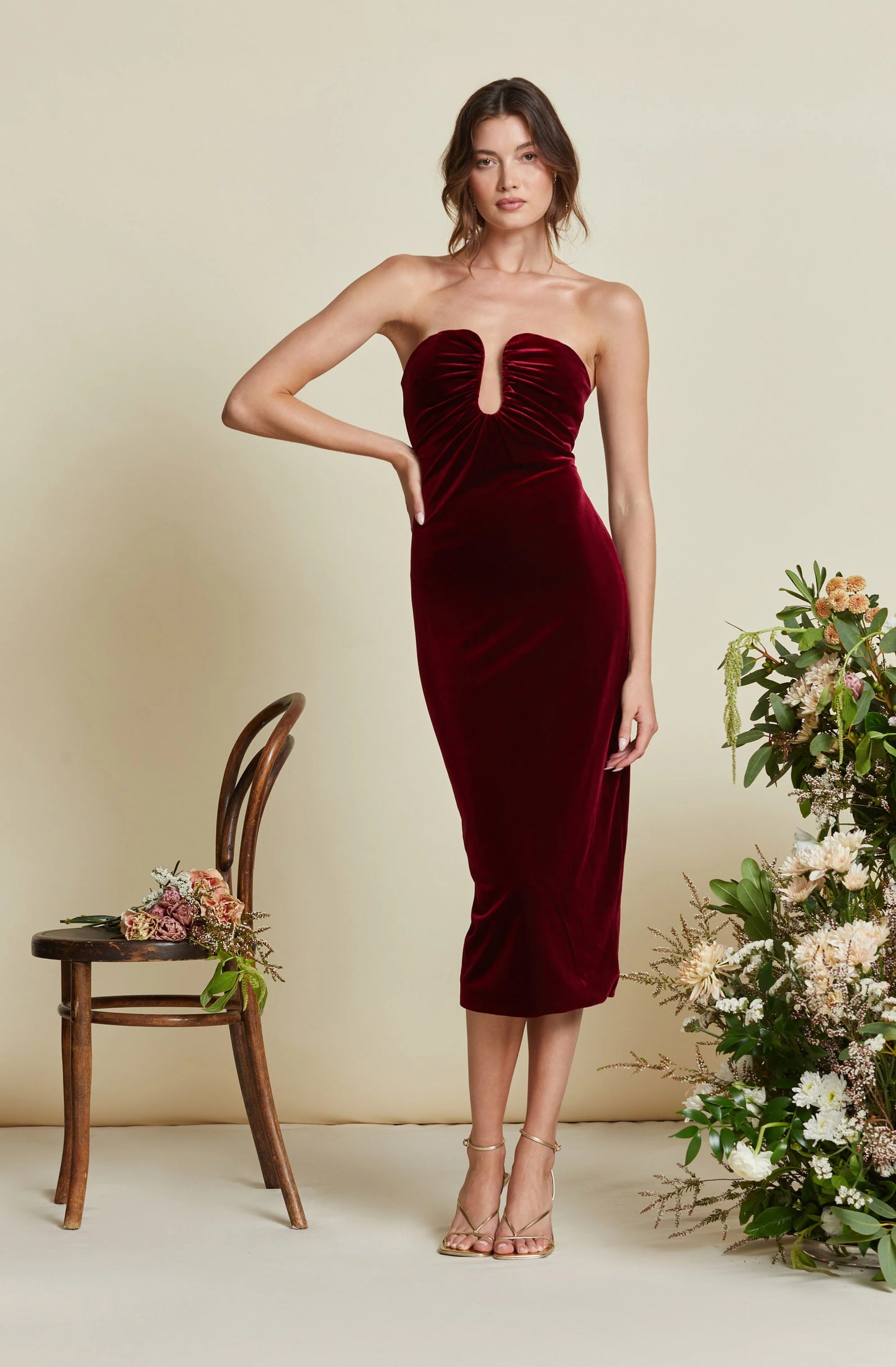 A woman wearing the Arista Sweetheart Velvet Midi Dress in the color Wine, by ASTR