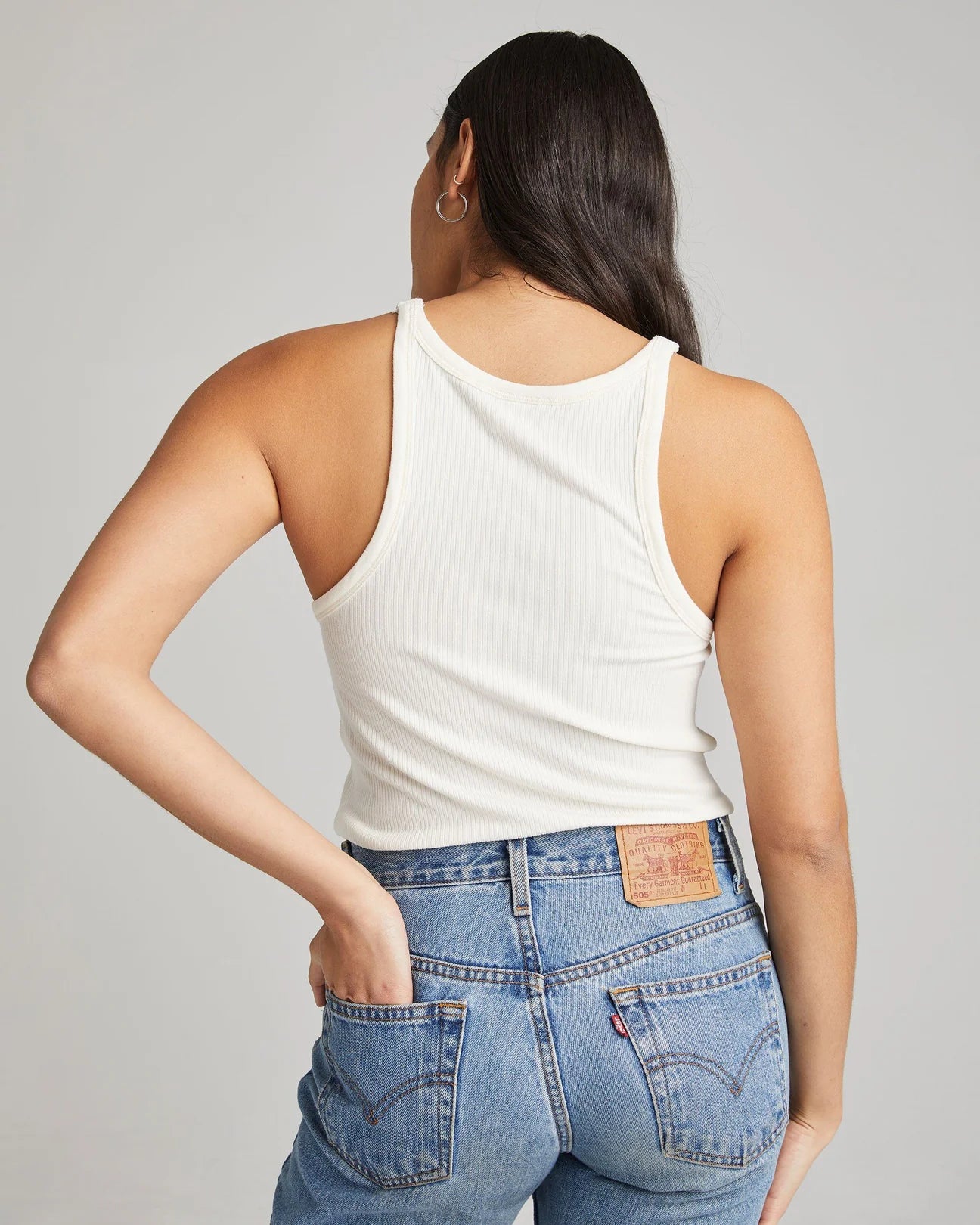 back view of model wearing white ribbed tank