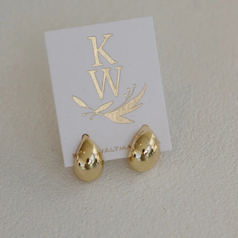Gold dome stud earrings on a white card with 'KW' branding.