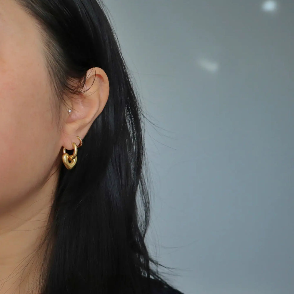 
                      
                        Small hoop earrings with a puffy heart charm
                      
                    