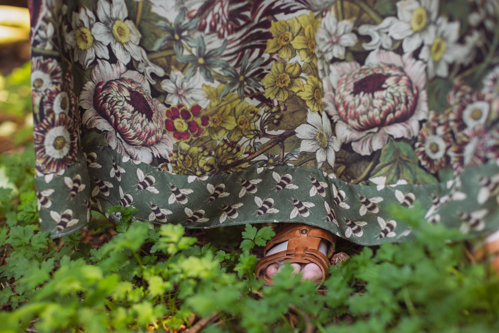 
                      
                        Person wearing a floral dress and sandals standing in grass
                      
                    