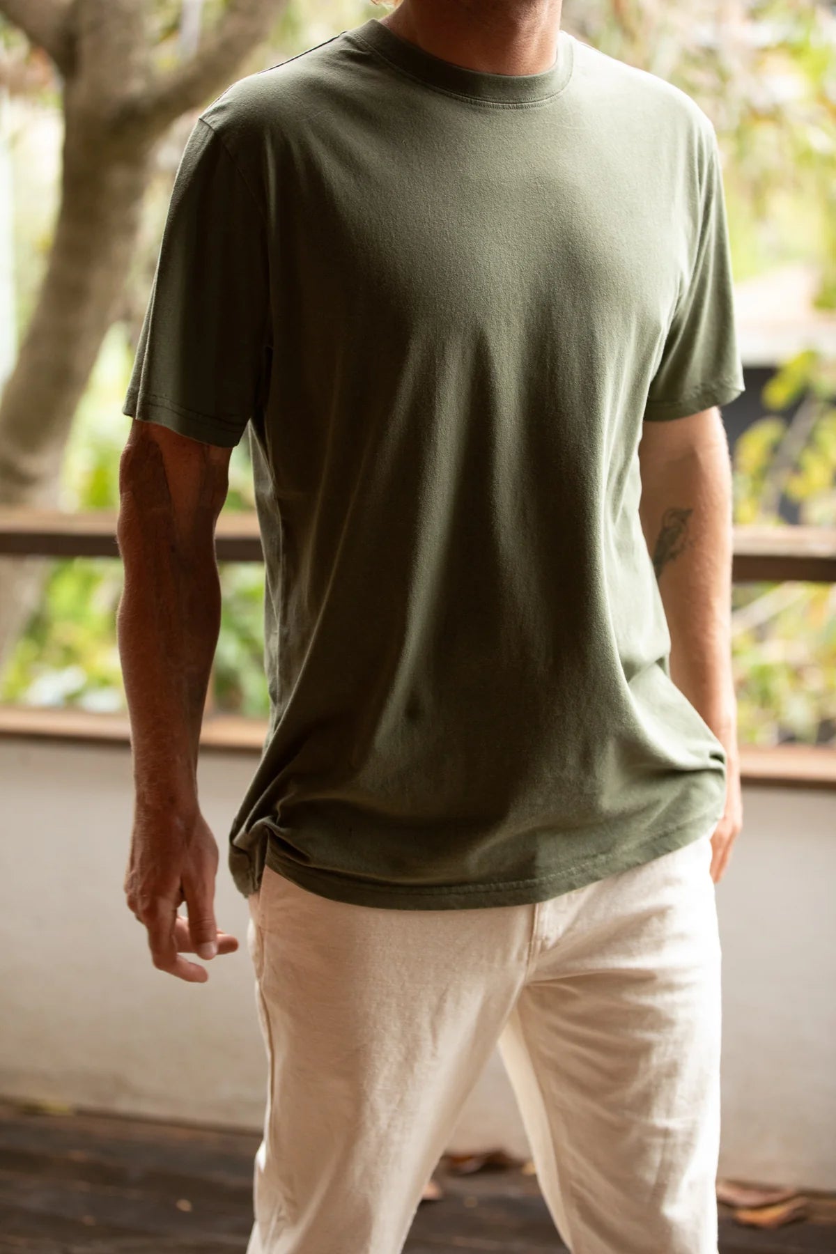 Man wearing the Classic Vintage Short Sleeve Tee in color olive green from Rhythm .