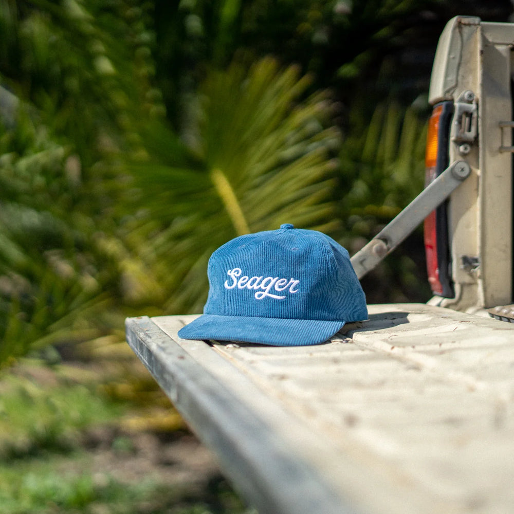 
                      
                        The Big Blue Corduroy Snapback hat by Seager sitting on the tailgate of a pickup truck
                      
                    