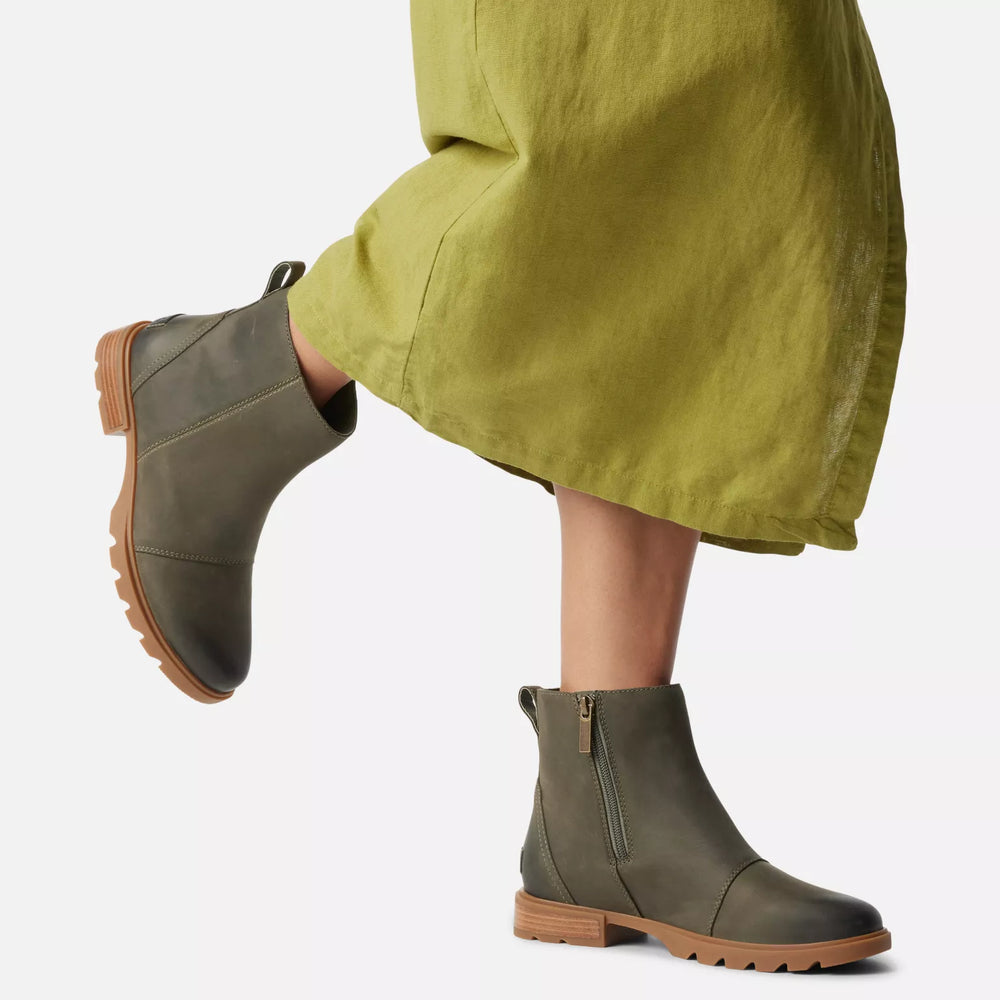 
                      
                        A woman wearing the Stone Green Emelie III Women's Zip Waterproof Bootie by Sorel
                      
                    