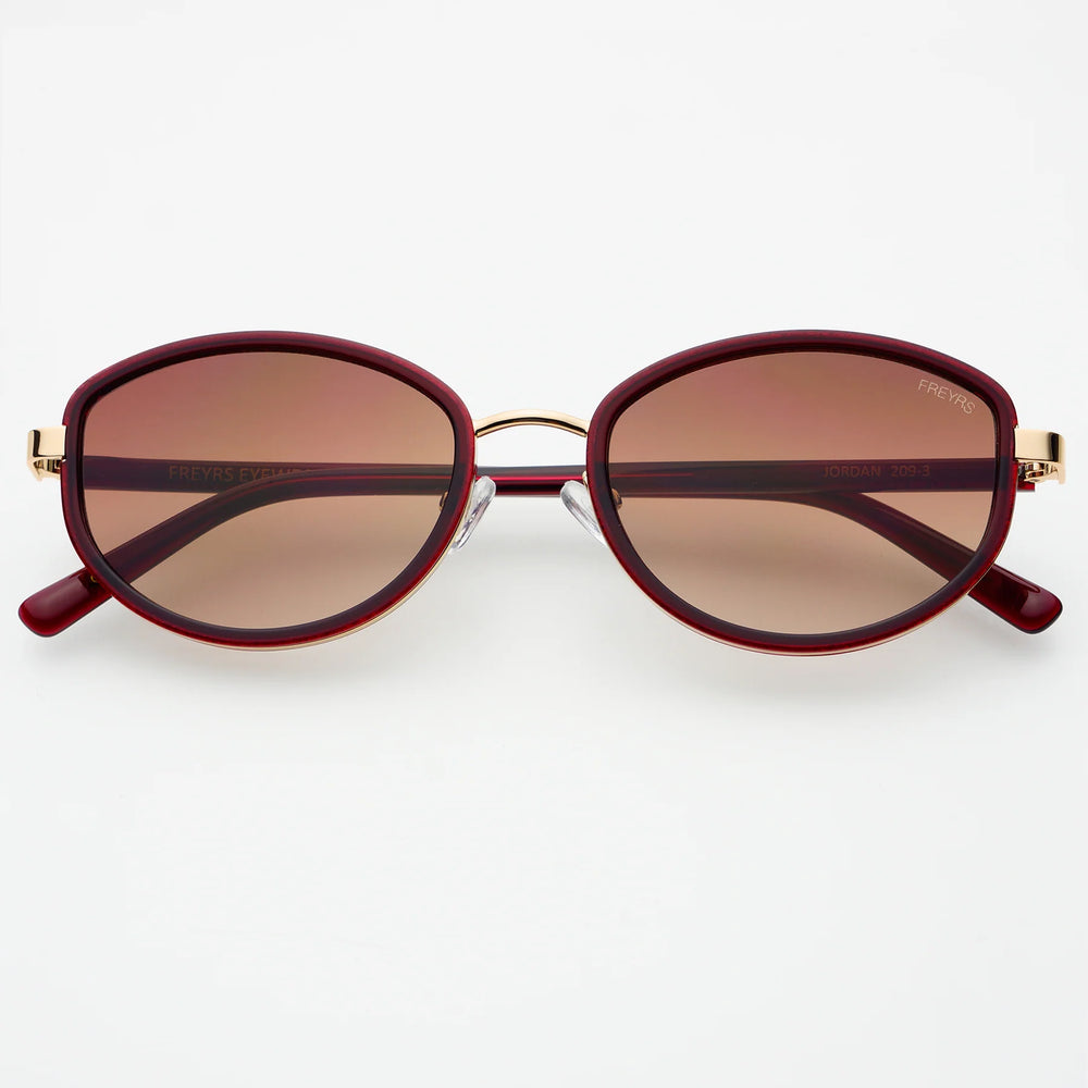 
                      
                        Oval shaped sunglasses with a burgundy frame 
                      
                    