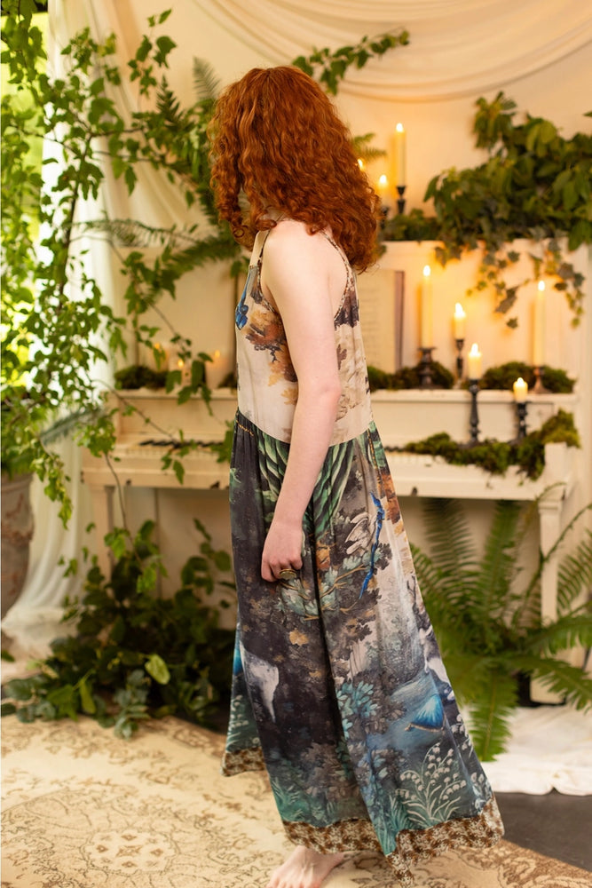 
                      
                        Woman in a floral dress from Market of Stars standing in a decorated room with plants and candles.
                      
                    