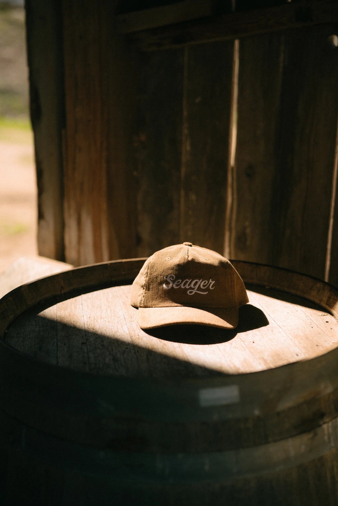 The Big Khak Corduroy Snapback Hat by the brand Seager styled on top of a barrel 