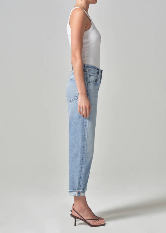 Side view of model wearing the light indigo Dahlia Bow Leg Baby Roll jeans by Citizens of Humanity