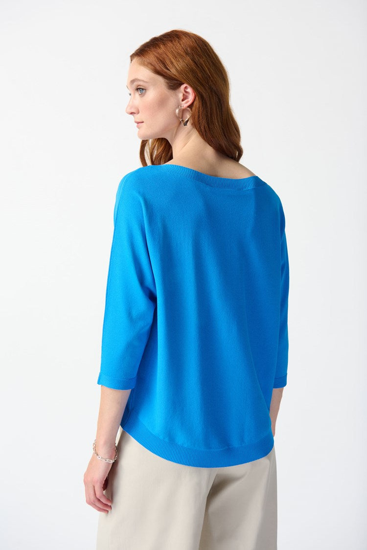 Back view of a woman wearing a bright blue pullover sweater