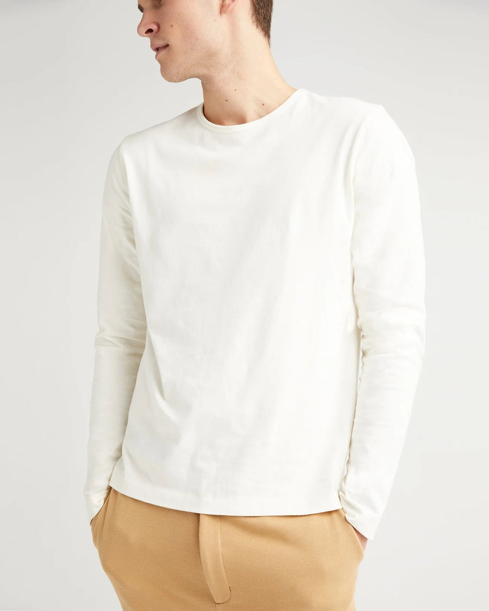 A man wearing the Weighted Organic Cotton Long Sleeve Tee by Richer Poorer in the color Bone