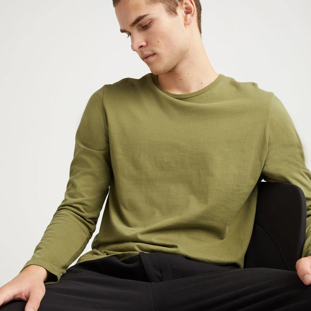 A man wearing the Weighted Organic Cotton Long Sleeve Tee by Richer Poorer in the color Olive Army