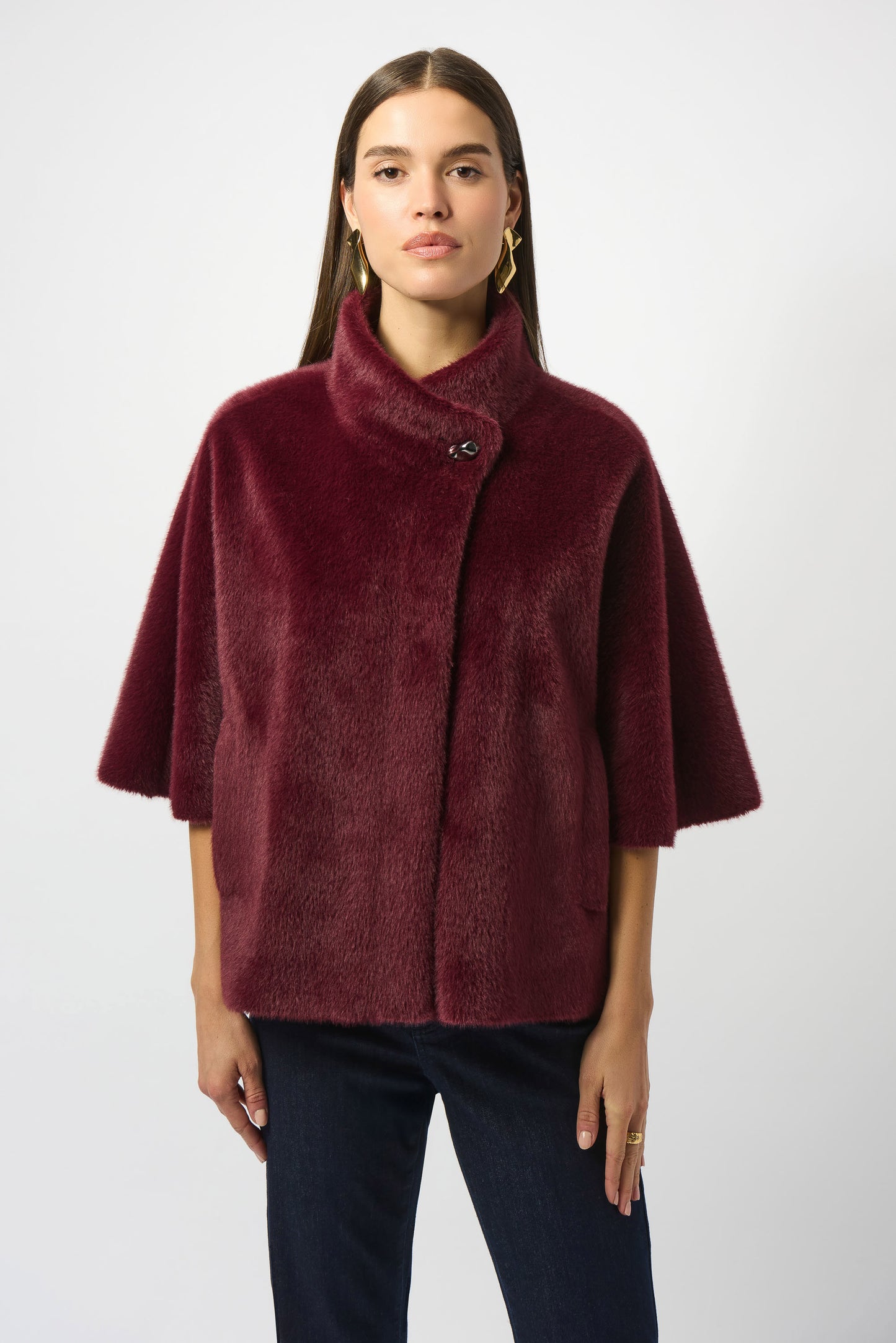 Woman wearing a burgundy mock collar faux fur jacket by Joseph Ribkoff