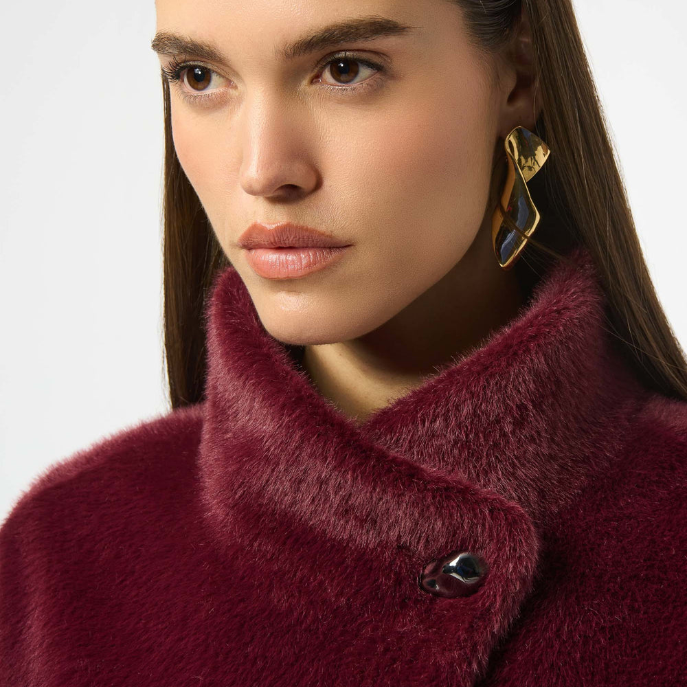 
                      
                        Close-up of a person wearing a burgundy coat with button closure at the mock neckline
                      
                    