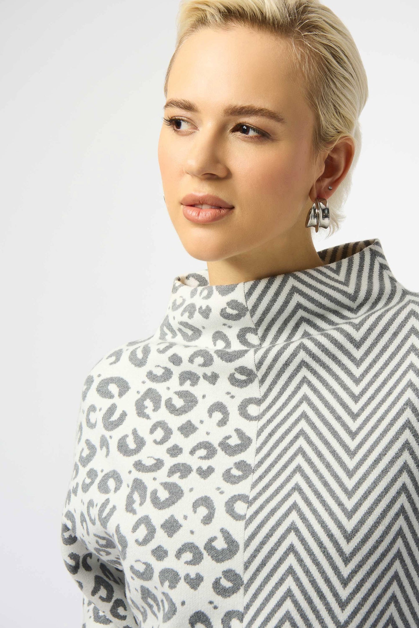 Person wearing a patterned garment with leopard print and zigzag design.