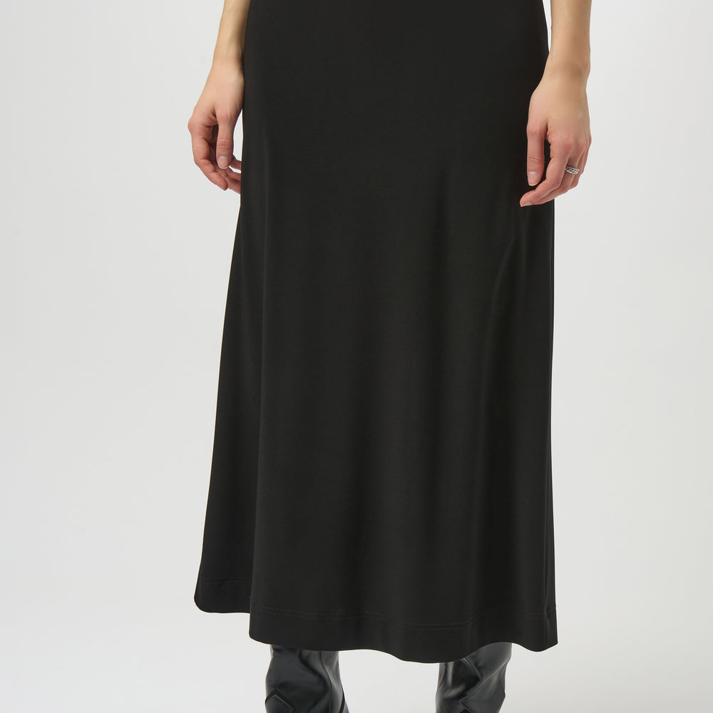 A woman wearing a black maxi skirt with black boots