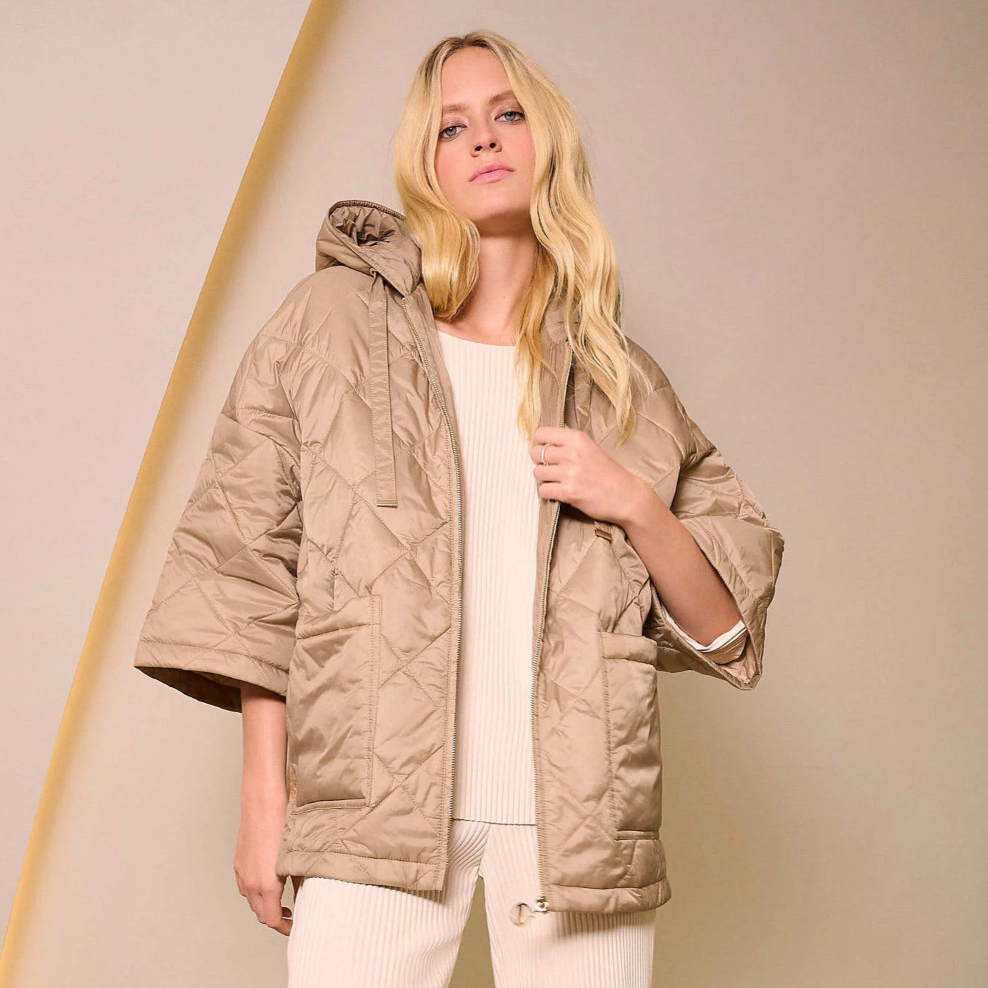 A woman wearing the Gold Woven Diamond Quilt Hooded Jacket by Joseph Ribkoff