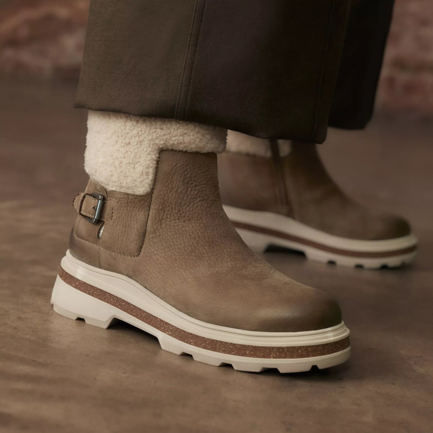 A pair of the Dark Sand Warmlined Hencroft Madi Waterproof Boot by the brand Clarks