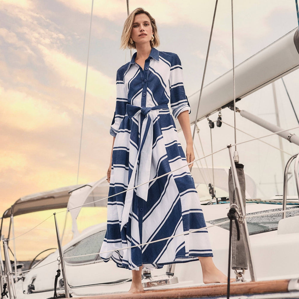 A woman standing on a boat while wearing the Cotton Stripe Print Fit and Flare Shirt Dress from Joseph Ribkoff