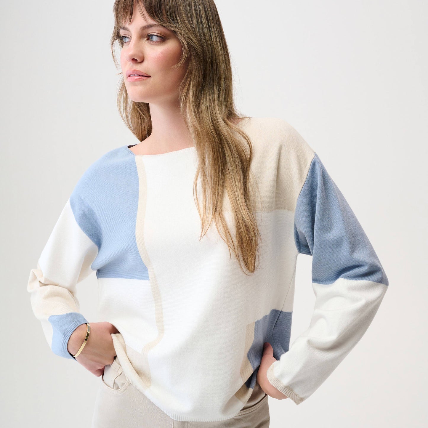 A woman wearing a color block pullover sweater from Joseph Ribkoff