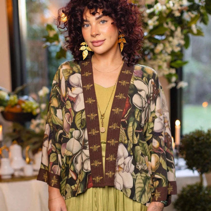 A woman wearing the Market Of Stars Fleur De Lune Pixie Duster Crop Kimono over a green dress