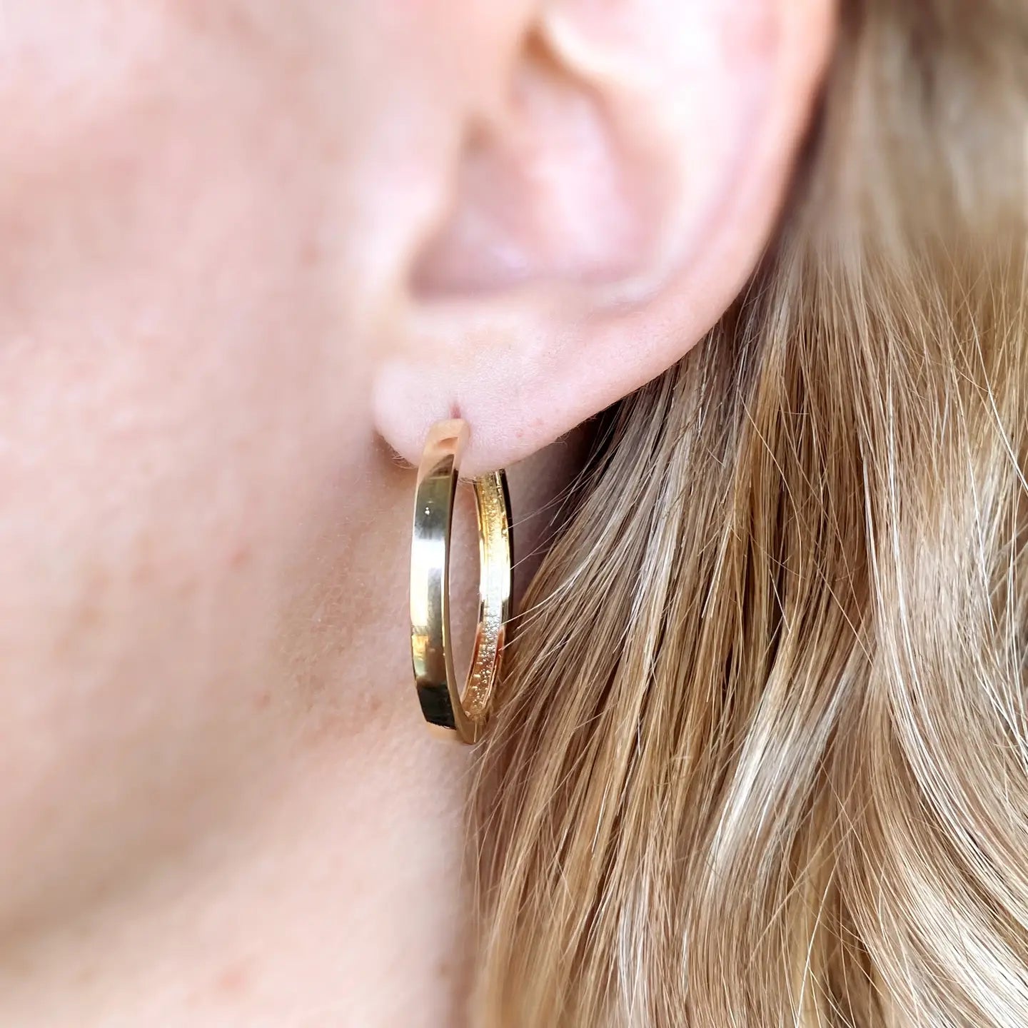 Flat gold hoop earrings measuring 30mm