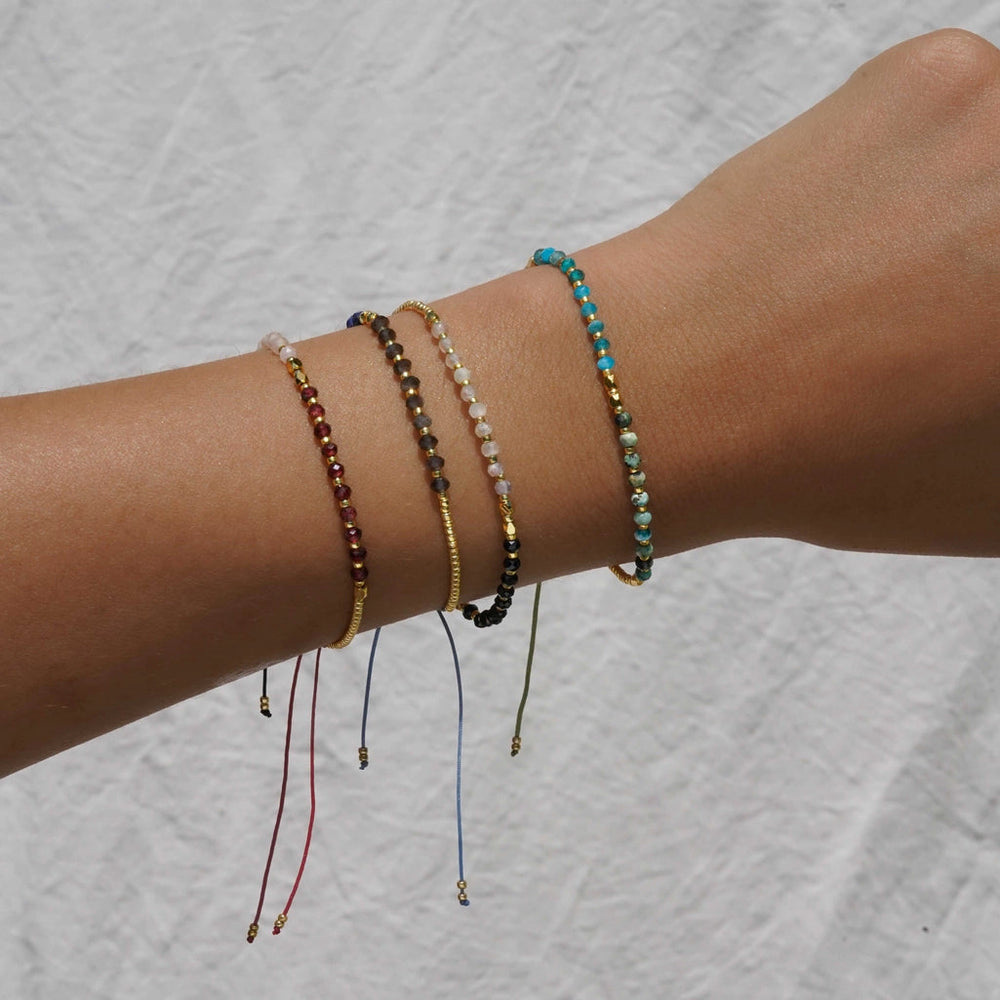 Wrist with multiple assorted gemstone bracelets from KOZAKH