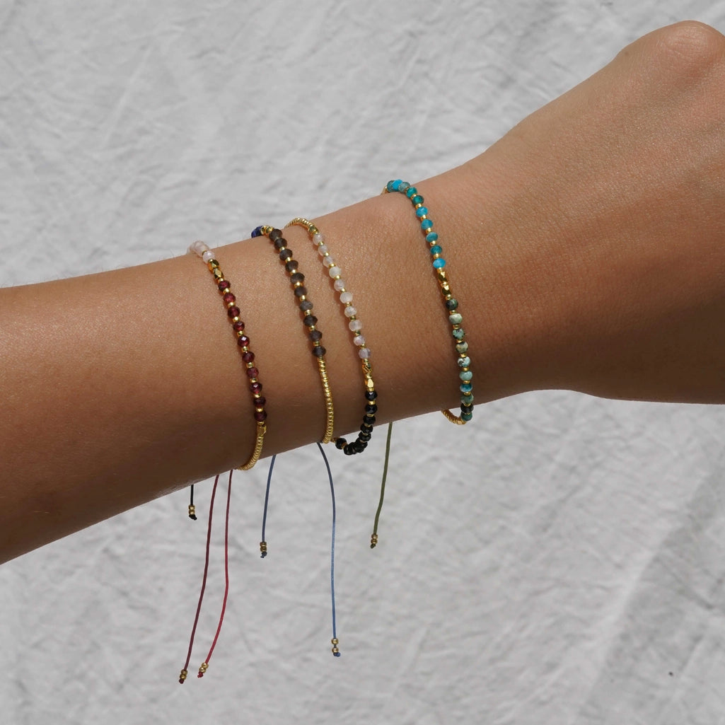 Wrist with multiple assorted gemstone bracelets from KOZAKH