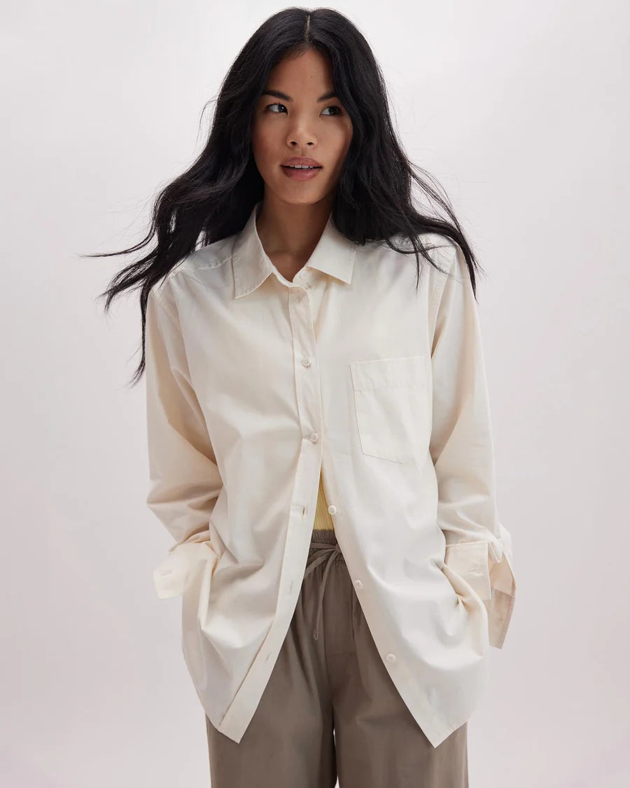 A woman wearing the Venice Button Up Shirt by Richer Poorer in the color Bone