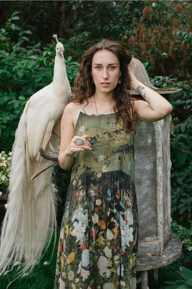 
                      
                        A woman standing next to a peacock while wearing the I Dream in Flowers Bohéme Slip Dress with Bees by Market of Stars
                      
                    