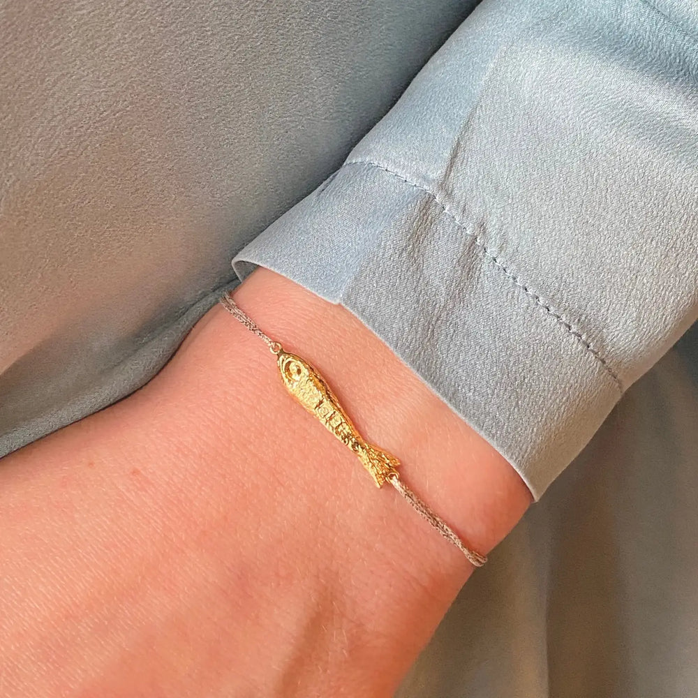 
                      
                        Person wearing the Ablette Gold Plated Fish Bracelet by Sophie Deschamps Bijoux
                      
                    