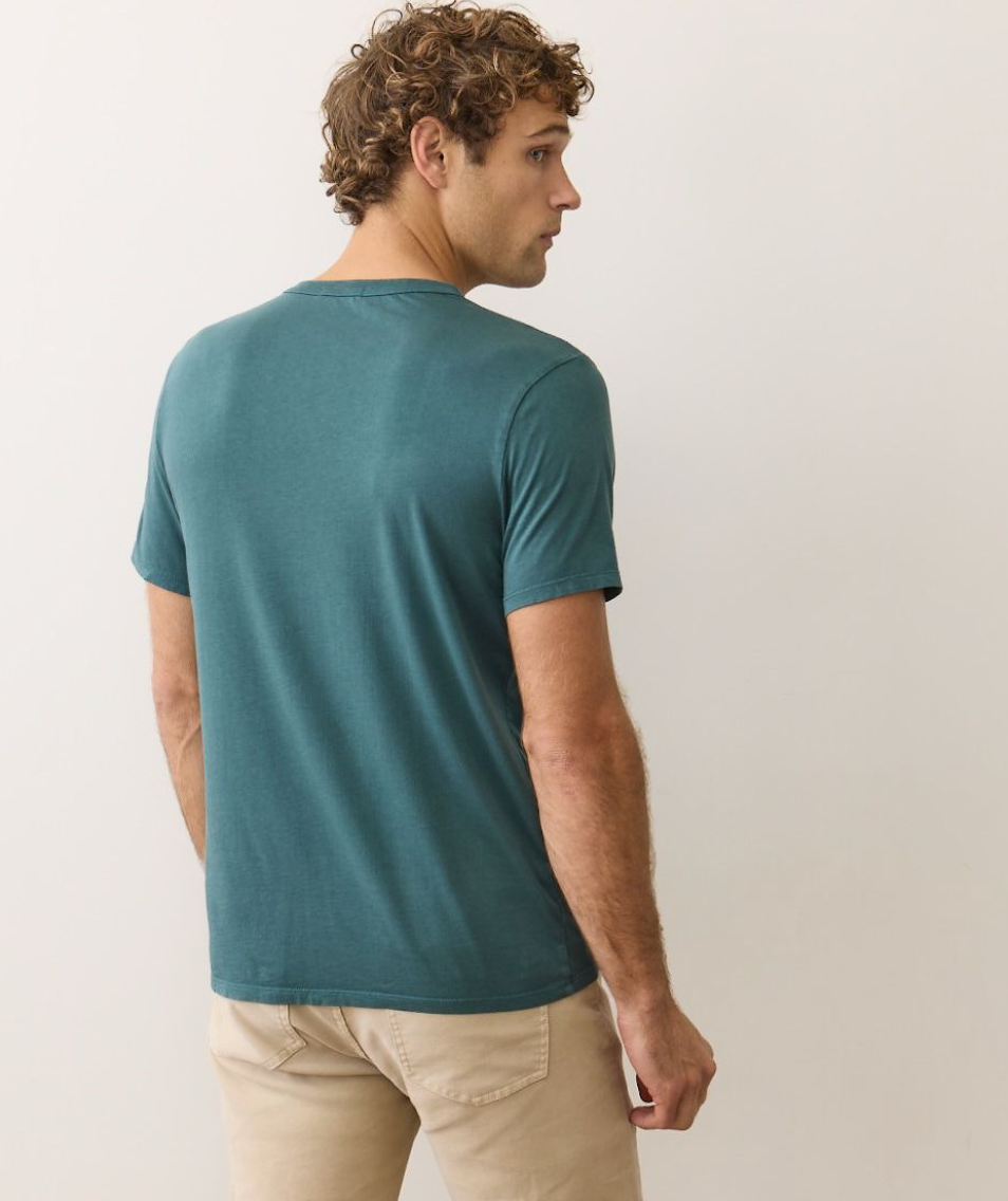 Man wearing a teal t-shirt and beige pants from Marine Layer