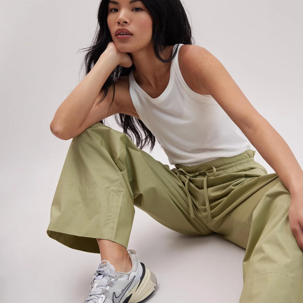 Woman sitting down while wearing the Green Ground Weekend Poplin Pants by Richer Poorer