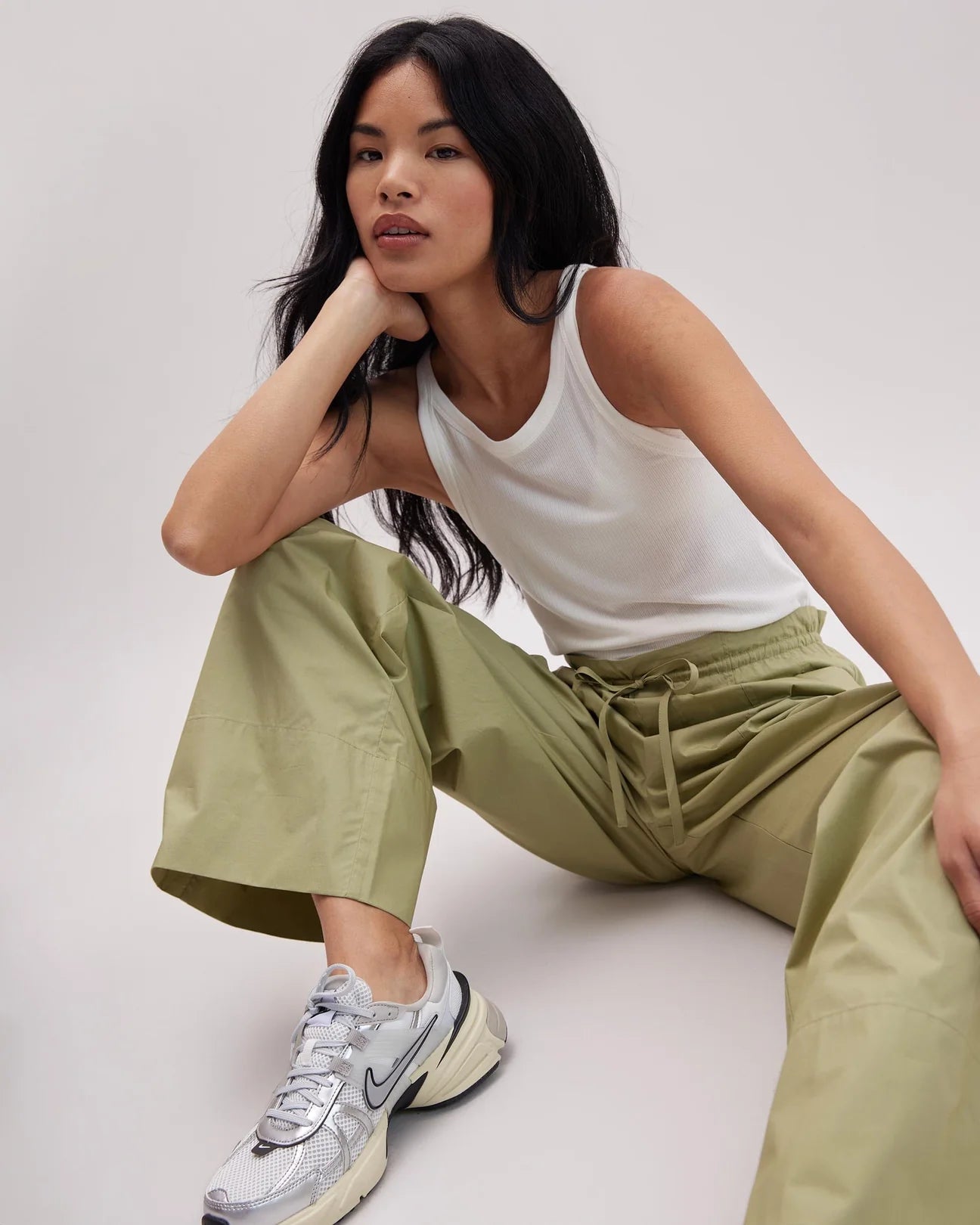 Woman sitting down while wearing the Green Ground Weekend Poplin Pants by Richer Poorer