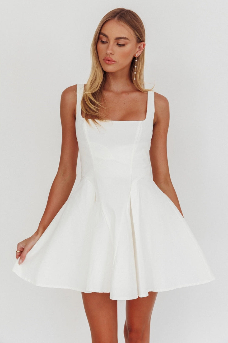 This flattering A-line mini dress at Harbour Thread features a square neckline, fitted bodice and a playful, pleated mini skirt. 