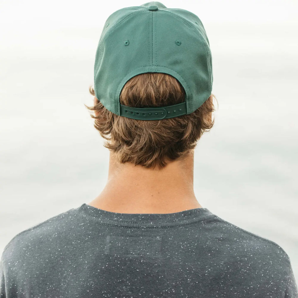 Person wearing a green cap from Mollusk