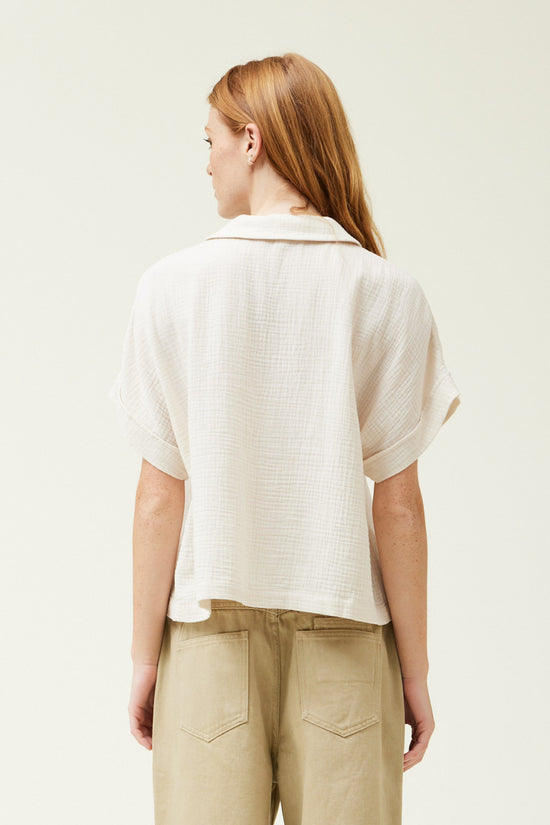 Load image into Gallery viewer, back view of woman wearing a white color short sleeve cotton gauze button up shirt
