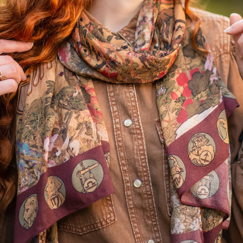 A woman wearing the Dreamweaver Bohemian Bamboo Scarf with Zodiac Signs by Market of Stars as a scarf around her neck